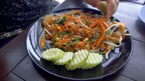 Man Squeezing Lime into Asian Noodle Dish Stock Footage 78803137