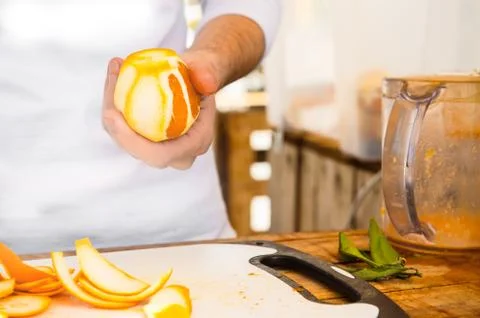 Man squeezing oranges on a table, preparing juice Stock-Fotos