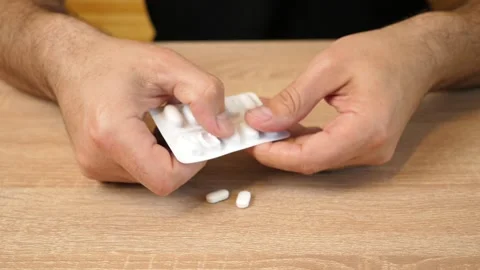 Man squeezing pills from blister pack. Taking medical devices. Stock Footage 318207537