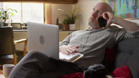Man with a stack of bills piling up gets bored and antsy while waiting on hold Stock Footage 133289968
