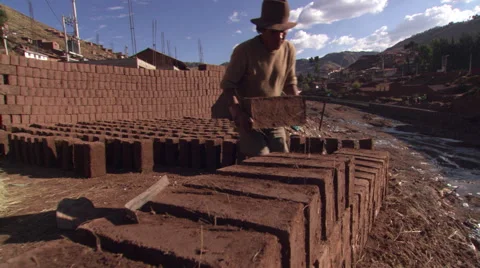 Man stacking adobe blocks at a brickyard in Cusco, Peru Stock Footage 59530421