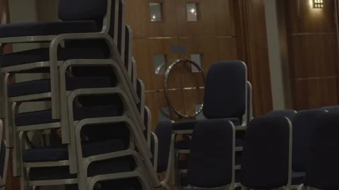 Man Stacking Blue Chairs in an Auditorium Stock Footage 342566764