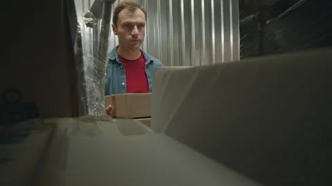 Man Stacking Boxes in Self Storage Room Stock Footage 259828969