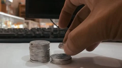 A man is stacking coins to tidy up on his desk 動画素材 202195397