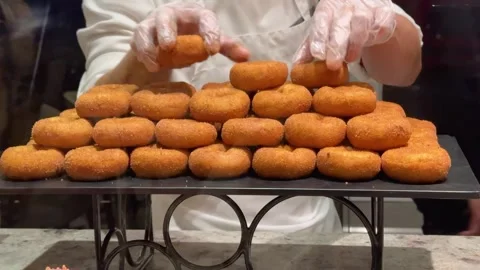 Man Stacking Donuts on Display Stock Footage 313613808