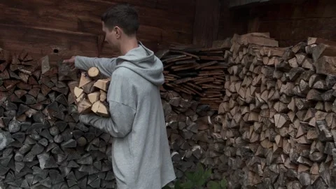 A man stacking firewood and preparations for the winter. Authentic look of a Stock Footage 295928820