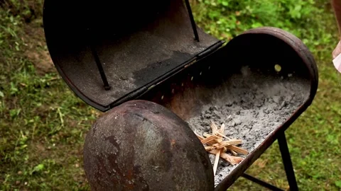 Man stacks wood chips in a brazier for making a fire Stock Footage 218973108
