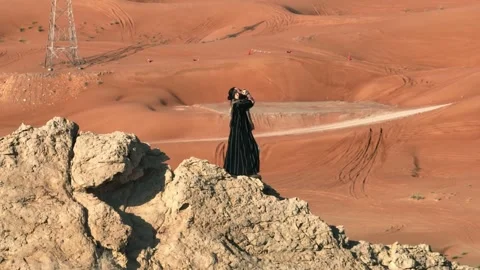 A man with a staff in his hand and the clothes of a shaman stands on a rock Stock Footage 248277893