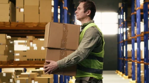 Man staff member sorting cardboard packages in logistics warehouse Stock Footage 332911338