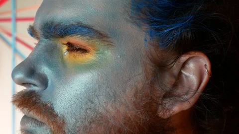 A man with a stage make-up. Portrait of a guy in a blue make-up, native or abori Video stock 87764287