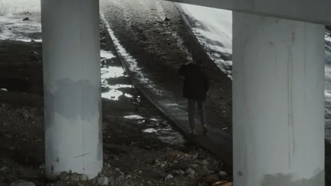Man Staggering as He Walking under Bridge with Concrete Supports Stock Footage 284258609