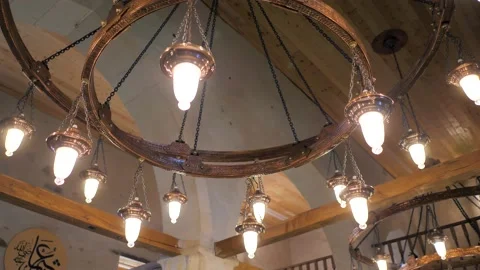 A man on the stairs changes a light bulb in an ancient chandelier in a mosque Stock Footage 201837234