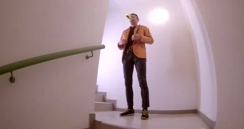 A man on stairs interacts, talks on phone, and takes photos Stock Footage 313564440