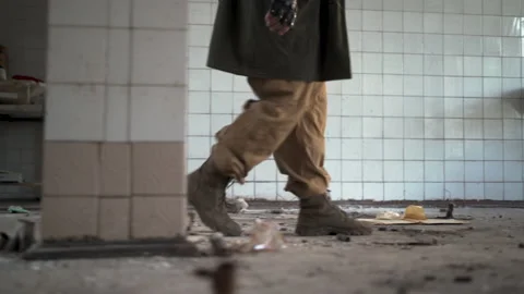 Man stalker walking in abandoned building on debris on floor. Dystopian, future Vídeos de archivo 207486304