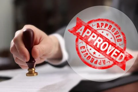Man stamping document at table and red stamp Approved 스톡 사진