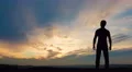 The man stand against the background of sunset. Time lapse. Wide angle 4k or 4k+ Resolution