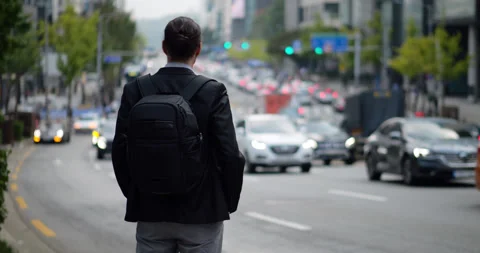Man stand back to us looking to slow traffic, selective focus shot Stock Footage 303994407