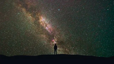 The man stand on a background of a milky way with asteroids skyfall. time lapse Stock Footage 78920516
