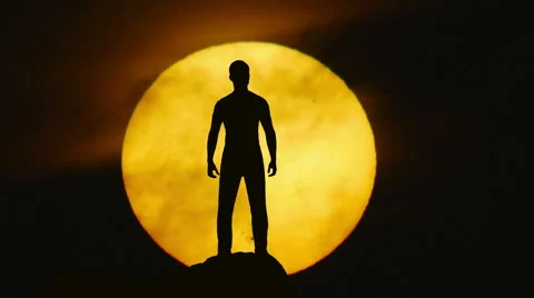 The man stand on a cliff on the background of sun. Real time capture Video stock 61239473