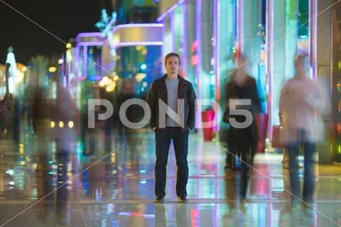 The man stand in the color alley. Evening night time Stock Photos