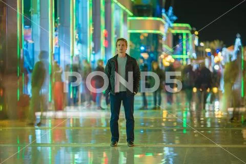 The man stand in the crowd stream. Evening night time Stock Photos