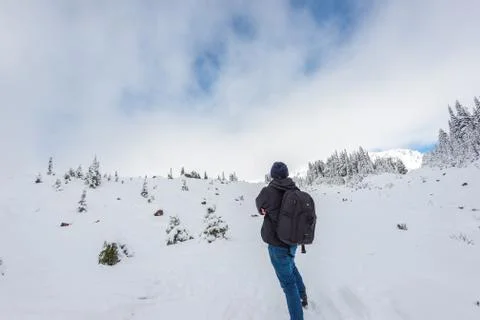 A man stand facing the mountain on a path cover with snow in paradise area,sc Stock Photos