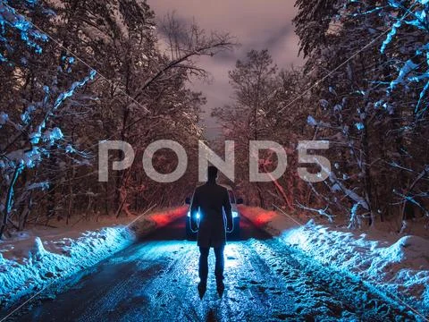 The man stand on the forest road near the car. evening night time Stock Photos