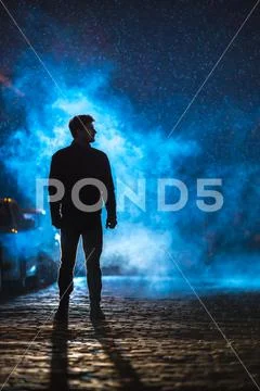 The man stand on the fume street. Evening night time. Telephoto lens shot Stock Photos