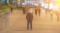 Man stand in ghost crowd stream. sunset on sunrise light flare seen. time lapse 4k or 4k+ Resolution