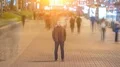 Man stand in ghost crowd stream. sunset on sunrise light flare seen. time lapse 4k or 4k+ Resolution