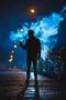 The man stand near the cloud of smoke. Evening night time Photo