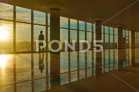 The man stand near the panoramic window against the background of the city Stock Photos