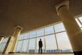 The man stand near panoramic window on the sunset background Photo