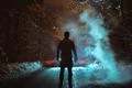 The man stand near the smoke on the forest road. evening night time Photo