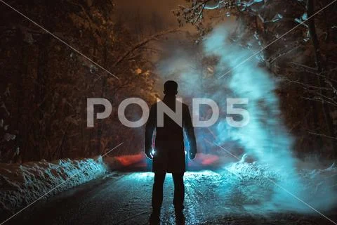 The man stand near the smoke on the forest road. evening night time Stock Photos