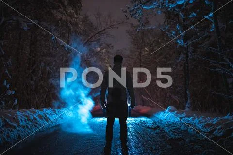 The man stand near the smoke in the winter forest. evening night time Stock Photos