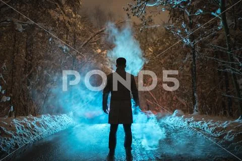 The man stand near the smoke in the winter forest. evening night time Stock Photos