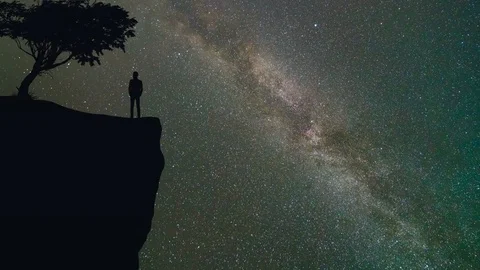 The man stand near a tree on the mountain against the meteor shower. time lapse Stock Footage 78919385