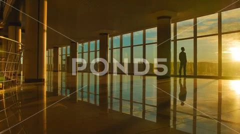 The man stand near the window against the background of the city Stock Photos