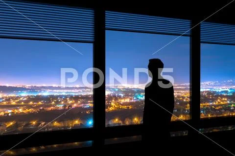 The man stand near the window on the cityscape background Stock Photos