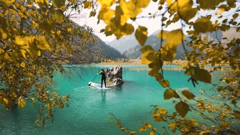 Man on stand up paddle board at mountain lake Stock Footage 159935786