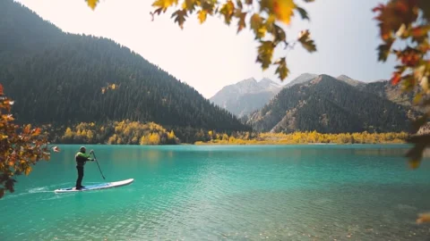 Man on stand up paddle board at mountain lake Vídeos de archivo 159935860