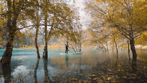 Man on stand up paddle board at mountain lake Stock Footage 159935920