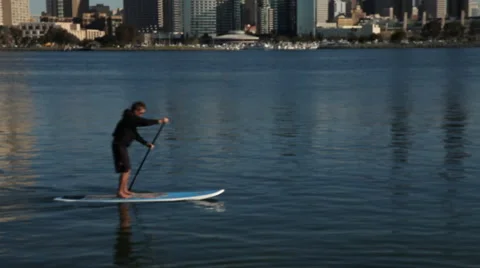 Man On A Stand Up Paddle Board Rows Somewhere Along the San Diego Shore Stock Footage 47072791
