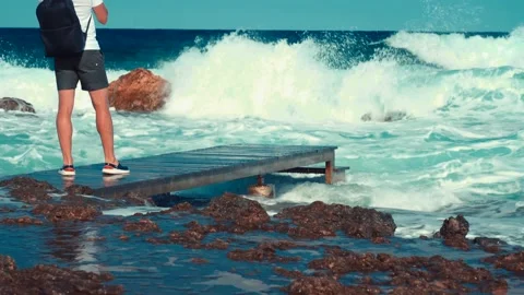 Man stand on pier and take a photo of blue sea waves Video stock 211174666