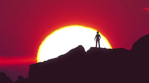The man stand on the rock on the background of sunset. Real time Stock-Footage 64263531
