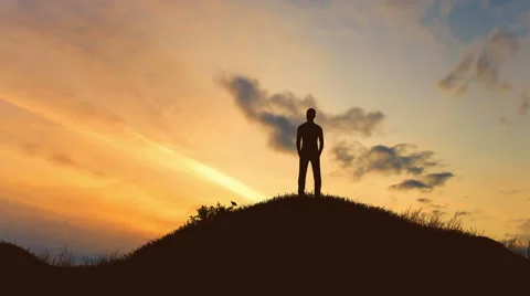 The man stand on the rock on the background of sunset. Real time Video stock 64265917