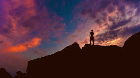 The man stand on the rock on the background of sunset. Time lapse Video stock 64266315