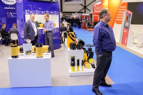 A man at the stand with samples of pipe products. Stock Photos