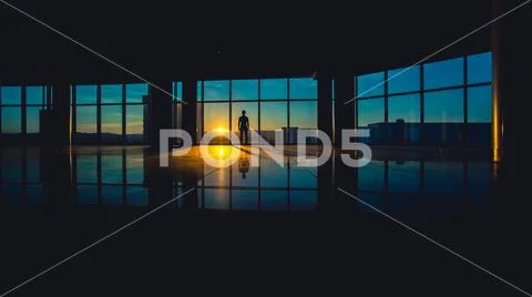 The man stand in a skyscraper business center windows on a background of suns Stock Photos